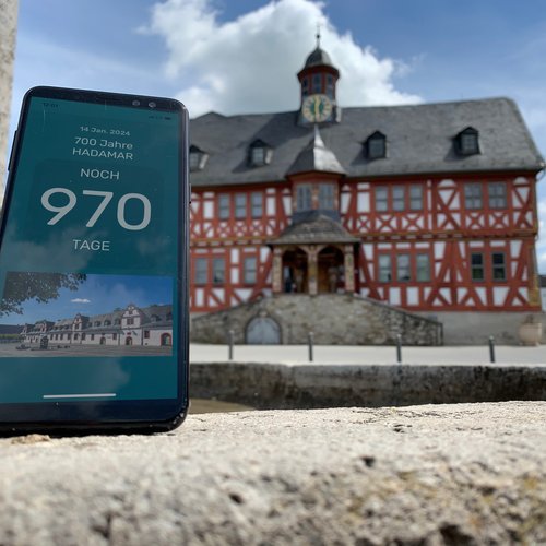 Ein Smartphone vor dem Hadamarer Rathaus zählt die verbleibenden Tage bis zum Stadtjubiläum