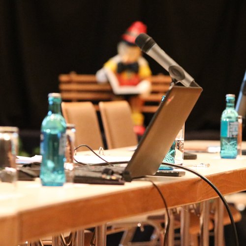 Ein Symbolbild von einer pol. Versammlung in Hadamar zeigt Mikrofone und einen Laptop in der Stadthalle in Nahaufnahme