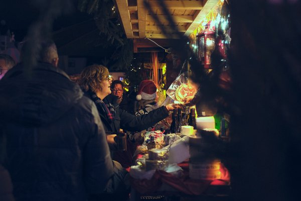 Eine Frau kauft an einer Weihnachtsmarkt-Hütte ein