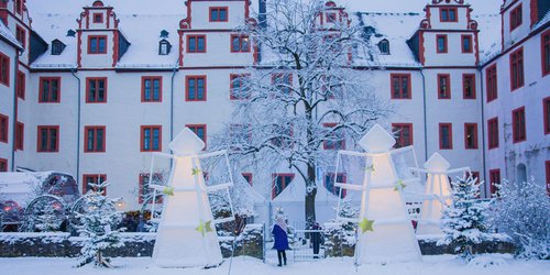 Ein Foto vom schneebedeckten Weihnachtsmarkt "Schloss der Engel" im Innenhof des Hadamarer Schlosses